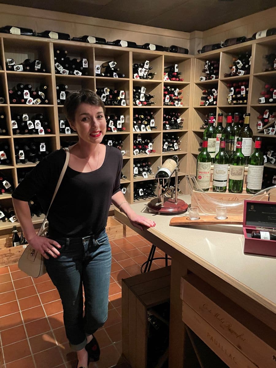 Posing beside a $10,000 bottle in Beverly's wine library.