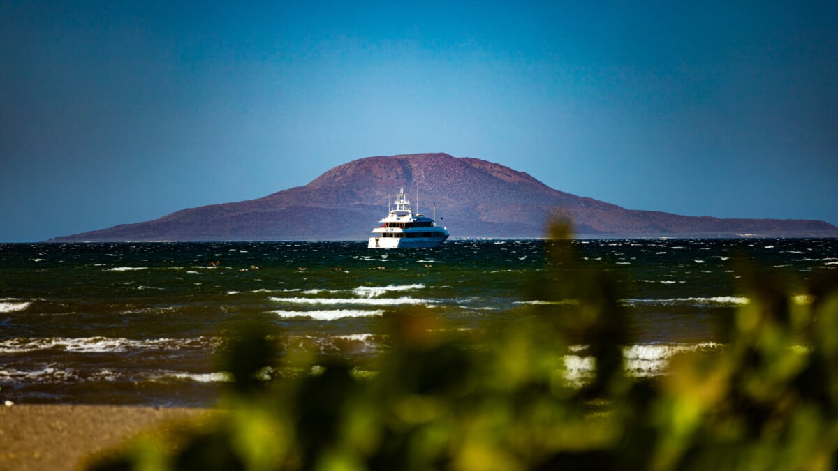 Across Bahiea de Loreto whee yachts are anchored for the night, the Coronados Volcano on Isla Coronados lures hikers to climb to the rim of its caldera. Photo by Eric Jay Toll