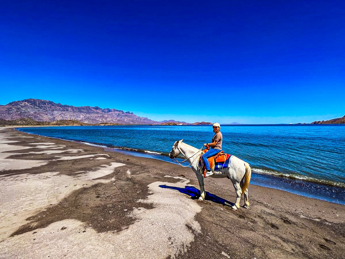 Writer Colleen Lanin sits astride her horse on the shores of Bahía de Loreto on a ride with guide Mario Perez across the desert to the sea. Photo by Colleen Lanin
