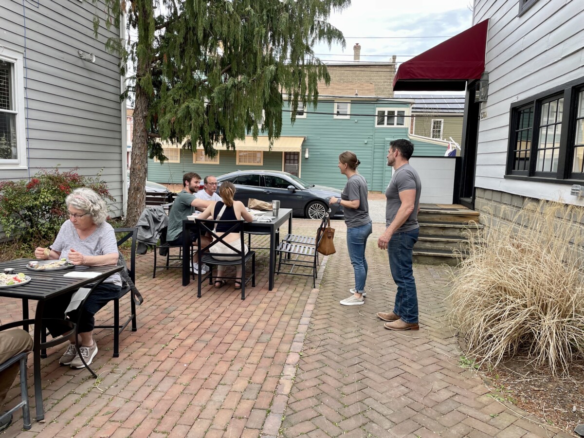 Modern Stone Age Kitchen owners chat with customers on the patio.