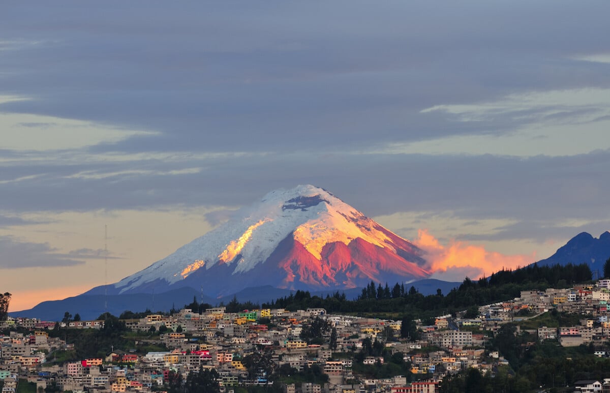 The last rays of sunlight illuminate the Cotopaxi Volcano towering above Quito, Ecuador. Photo by Fabricio Burbano via iStock by Getty Images