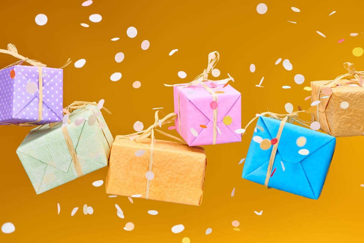 falling confetti near colorful gifts on orange