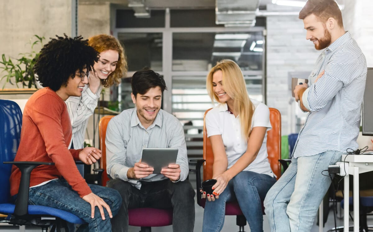 Professional young business team considering new project, manager holding digital tablet, office interior