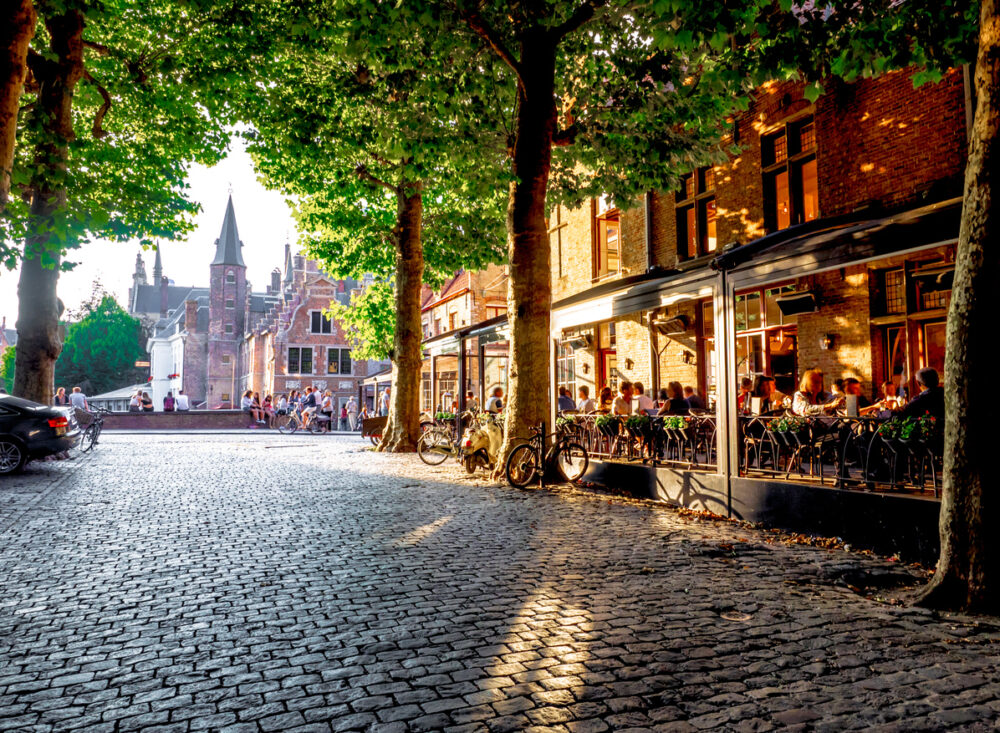 Discover the Charms of Bruges and Knokke-Heist, Belgium 2 view Bruges' bridges from a tree-lined road