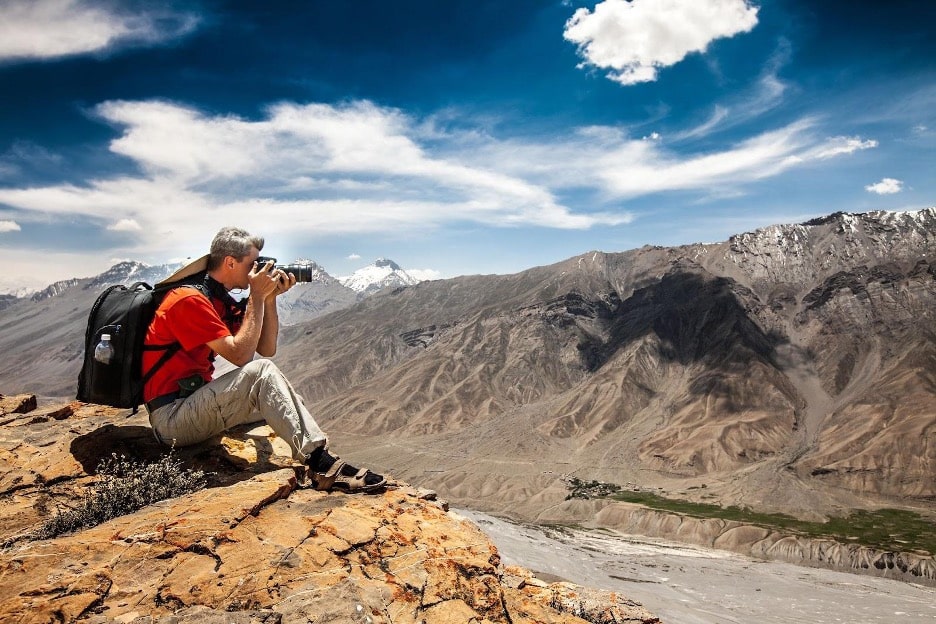Man with camera checking out the top travel photography trends
