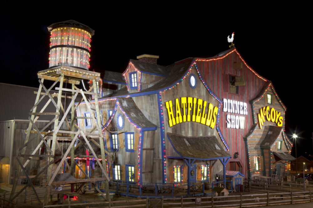 Pigeon Forge, Tennessee, USA - January 9, 2014: The unique facade of the Hatfield & McCoy Dinner Show Theater make it a landmark and major tourist attraction in Pigeon Forge, Tennessee. The facade of the building resembles a large old farm barn with water tower. Live animals including goats, pigs and chickens are kept in the fence in area just outside the building. The dinner theater provides country humor entertainment while serving a typical country meal.