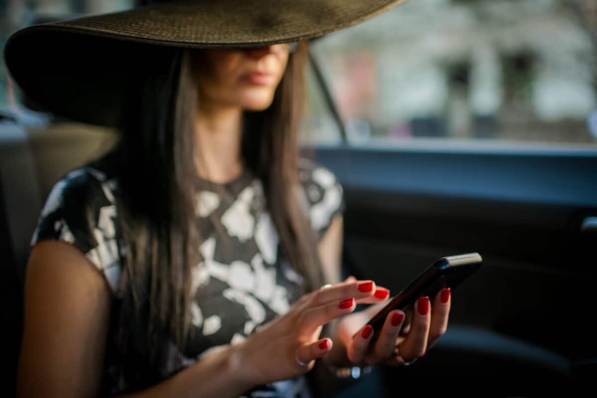 Young woman in taxi.Text messaging