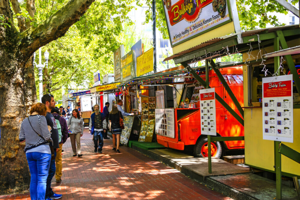 Unveiling Portland, Oregon: A Treasure Trove of Diverse Attractions 3 People ordering food from the multi-ethnic fast-food vendors in downtown Portland, Oregon