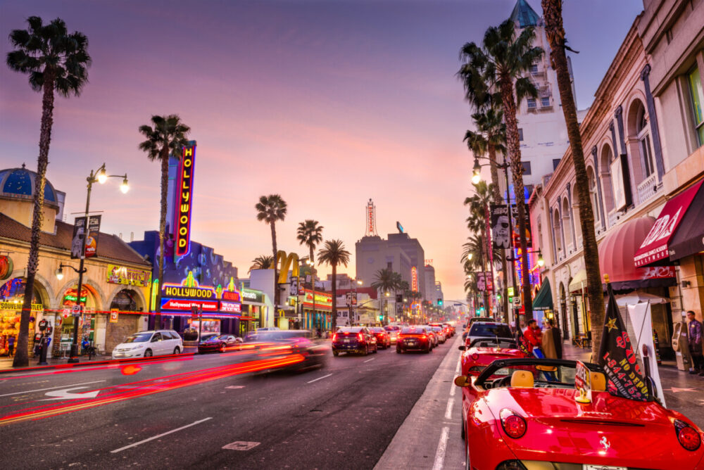 Exploring Los Angeles: What to Expect When Visiting the City of Angels 4 Traffic and pedestrians on Hollywood Boulevard at dusk. The theater district serves as a famous tourist attraction while exploring Los Angeles.