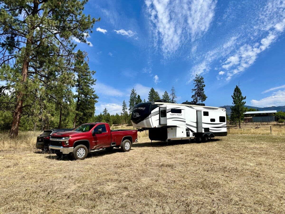 Red truck pulling a fifth-wheel trailer. Buy an RV online.
