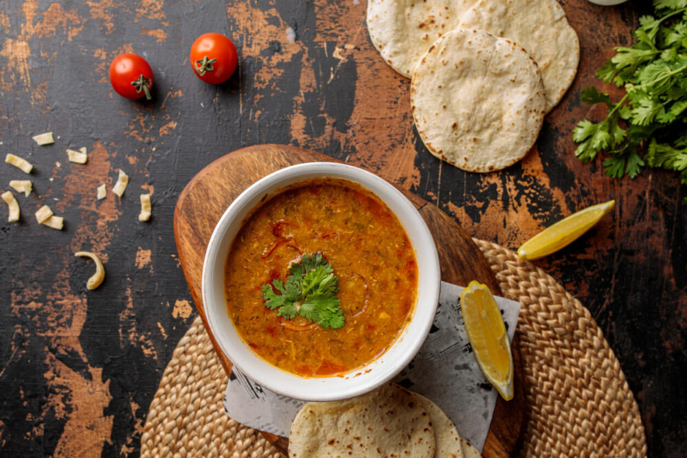 Madrooba or Madrouba soup with bread, lime and tomato cherry served in dish isolated on table top view of arabic breakfast