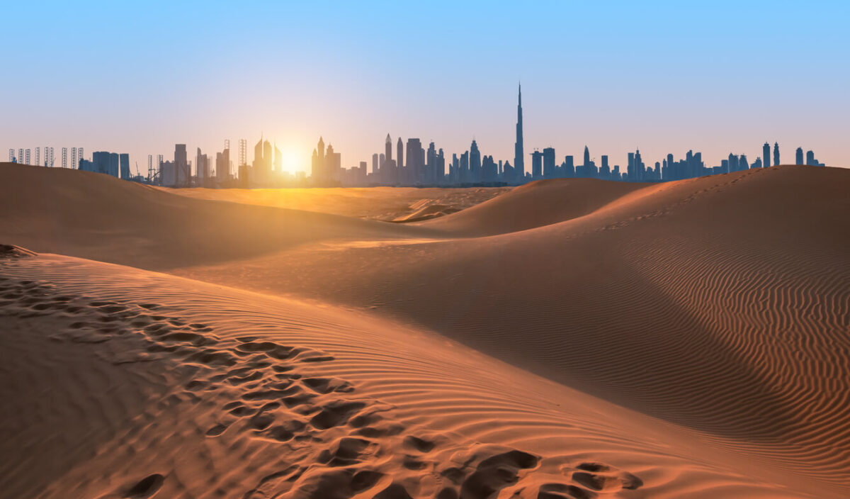 Desert Safari Adventure in Dubai with the sun setting behind the silhouette of Dubai