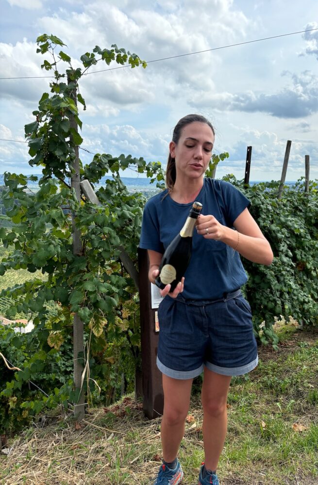 Woman opening wine in the vineyard