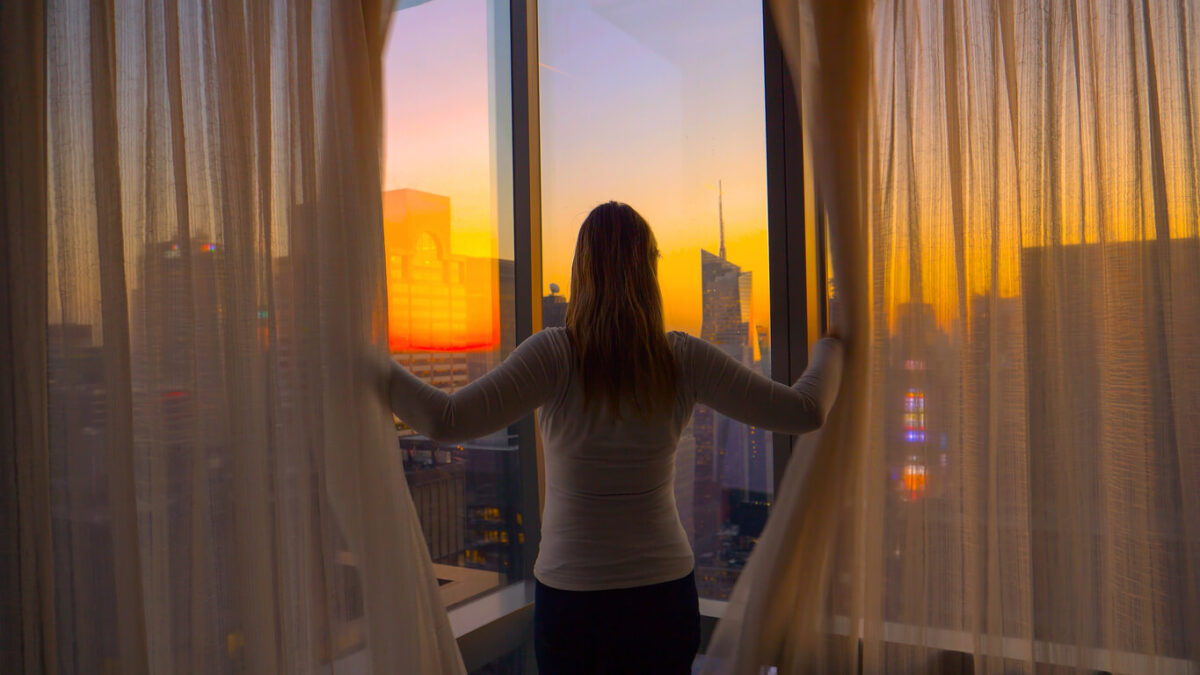 woman looking out of a window at NYC