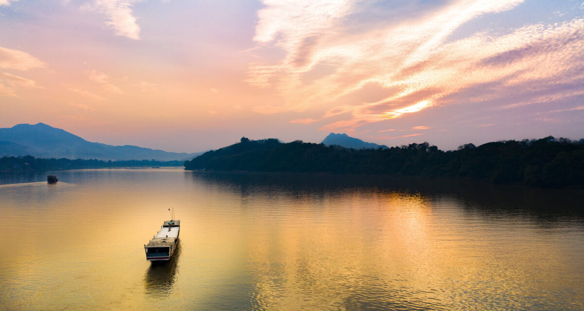 aerial view of a tourists boat sailing along the Mekong river at sunset