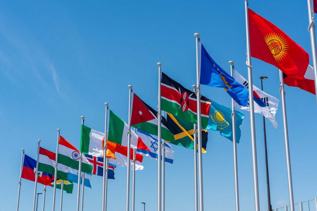 International Flags flying high against clear sky at the Entrance of Expo 2025 Osaka Kansai.