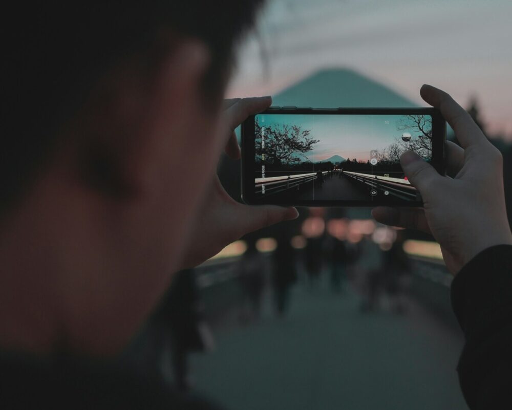 How to Shoot Magazine‑Worthy Travel Images With Your Smartphone 2 person taking photo of city during daytime