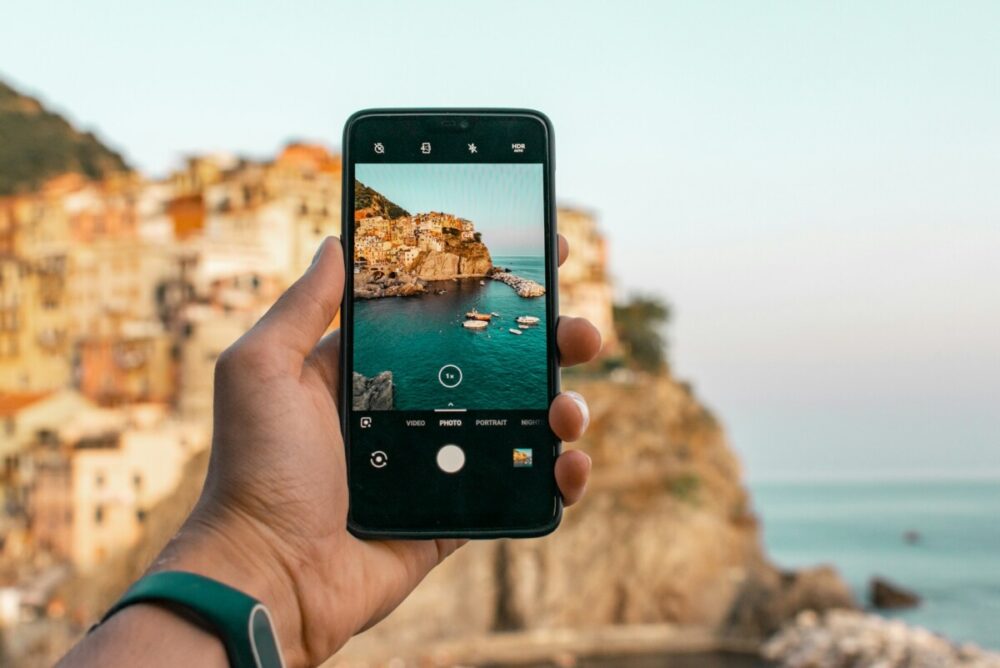 How to Shoot Magazine‑Worthy Travel Images With Your Smartphone 1 person holding a phone near cliff during daytime