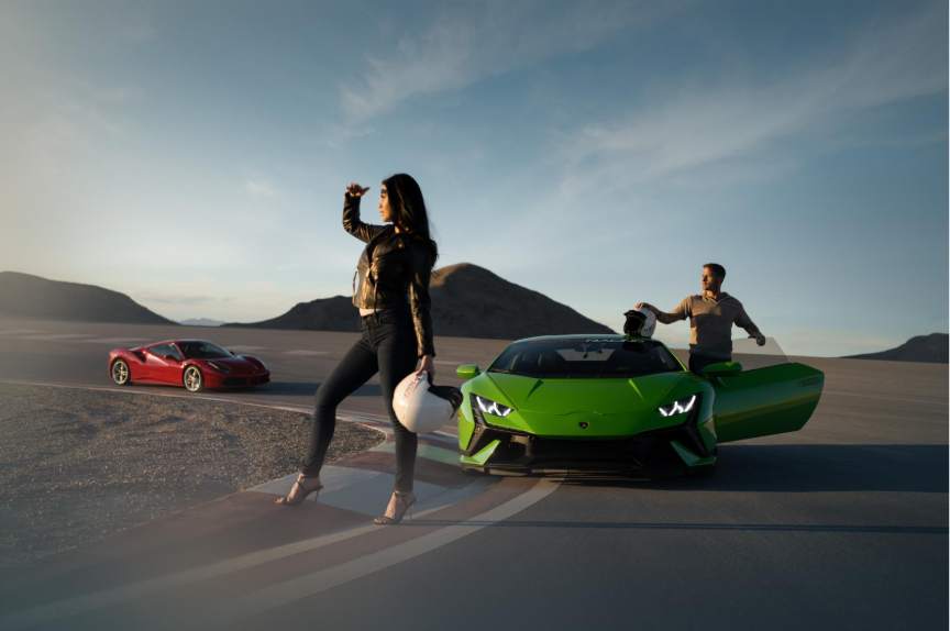 Woman standing on a racetrack with a green and red racecar behind her