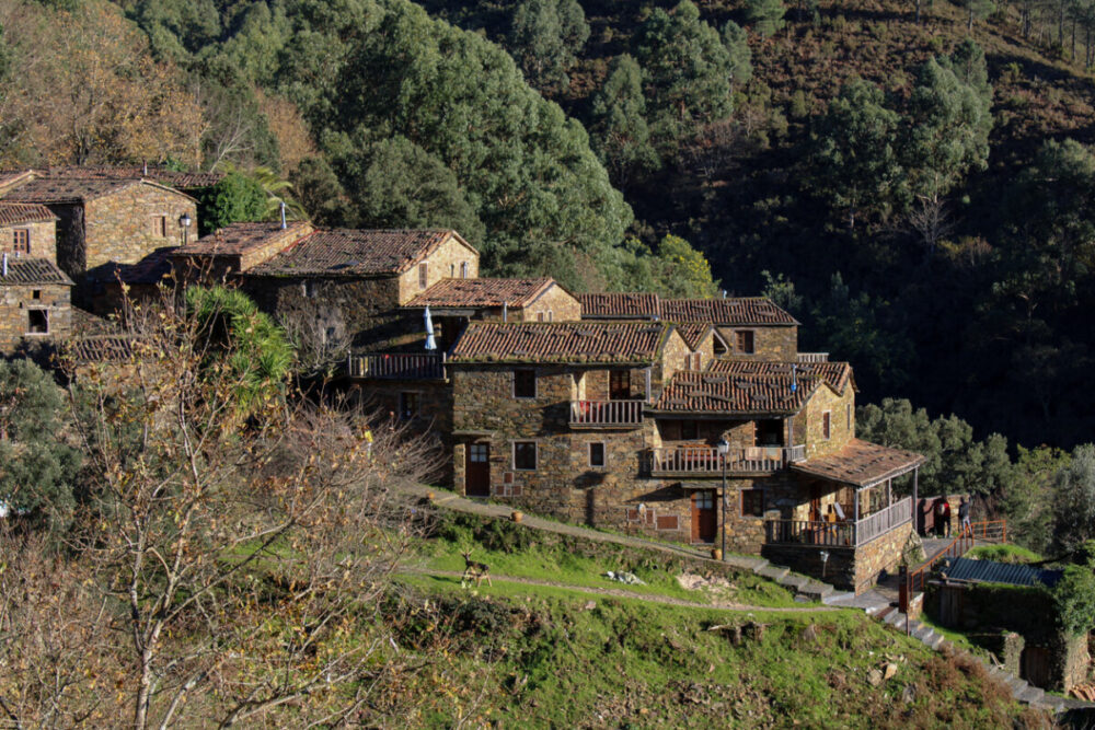 The Secret Corners Of Portugal That Most Travel Guides Don't Tell You About 7 Schist houses surrounded by the mountains and trees.