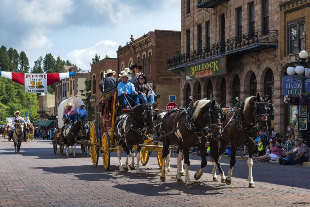 Black Hills, South Dakota Summer Travel Guide: Best Things to Do and Where to Go 26 A stagecoach with horses going down Historic Main Street in Deadwood, SD.