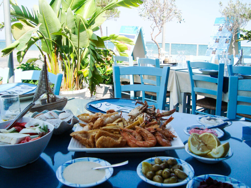 Some of the Best Worldwide Destinations For Food Lovers 2 Mediterranean cuisine. saganaki shrimp. table setting. a plate with seafood on a table in a cafe