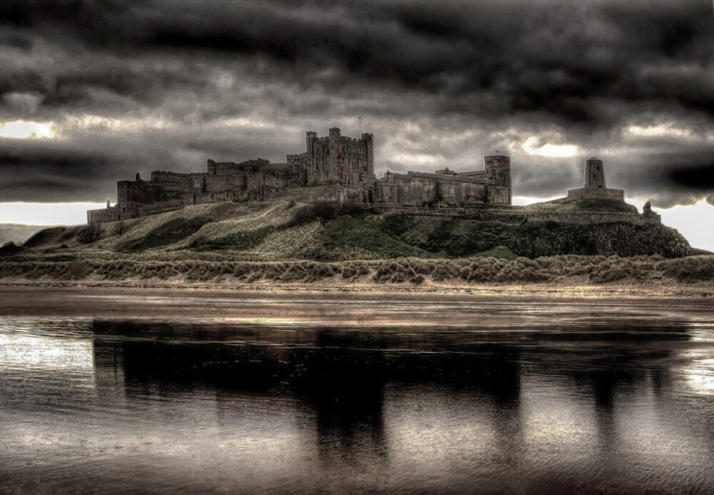 Best Scenic Coastal Escapes in the UK for Unforgettable Views 1 Dramatic storm clouds over Bamburg Castle on the Northumberland shore. An outstanding place for scenic coastal escapes in the UK.