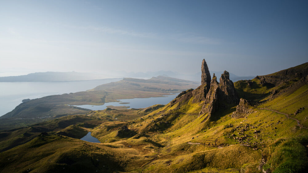 Best Scenic Coastal Escapes in the UK for Unforgettable Views 3 Stone spires, called the Old Man of Storr, high on a hillside above the sea. An ideal place for scenic coastal escapes in the UK.