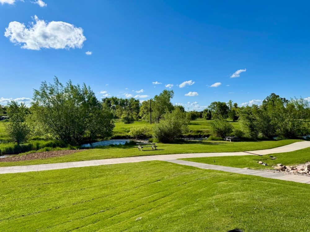 Black Hills, South Dakota Summer Travel Guide: Best Things to Do and Where to Go 21 green space with walking paths, trees, and creek