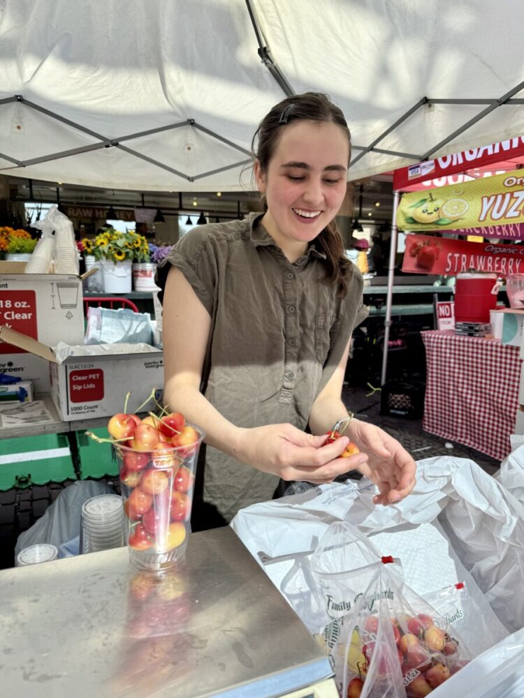 A Seattle Food Itinerary: 2 Days of Pike Place Market, Seafood, and Wine 9 woman from Martin Family Orchards putting cherries in a container