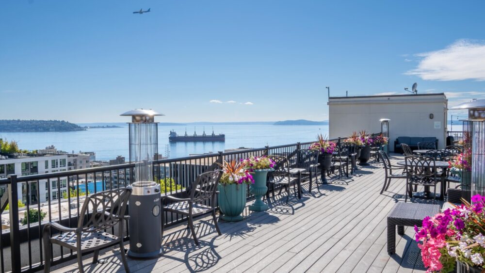 Mediterranean Inn Seattle: A Comfortable Stay in Queen Anne 7 rooftop deck with chairs and tables looking out at the water