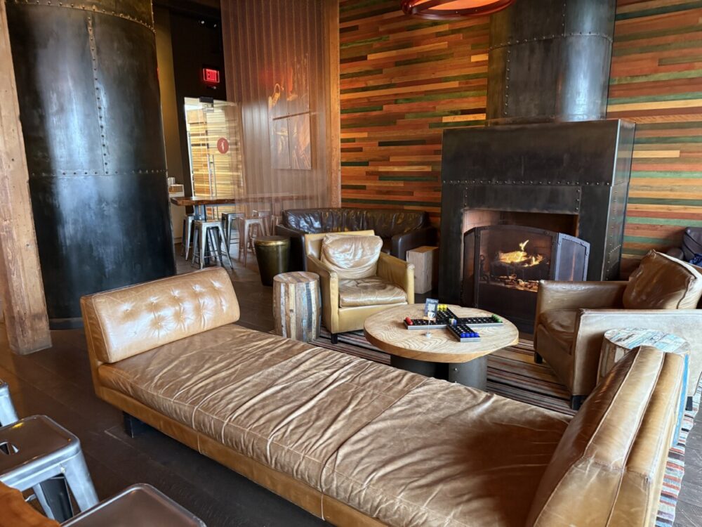 A Seattle Food Itinerary: 2 Days of Pike Place Market, Seafood, and Wine 13 Interior of Storyville Coffee at Pike Place Market in Seattle with a long bench, comfortable chairs and a fireplace