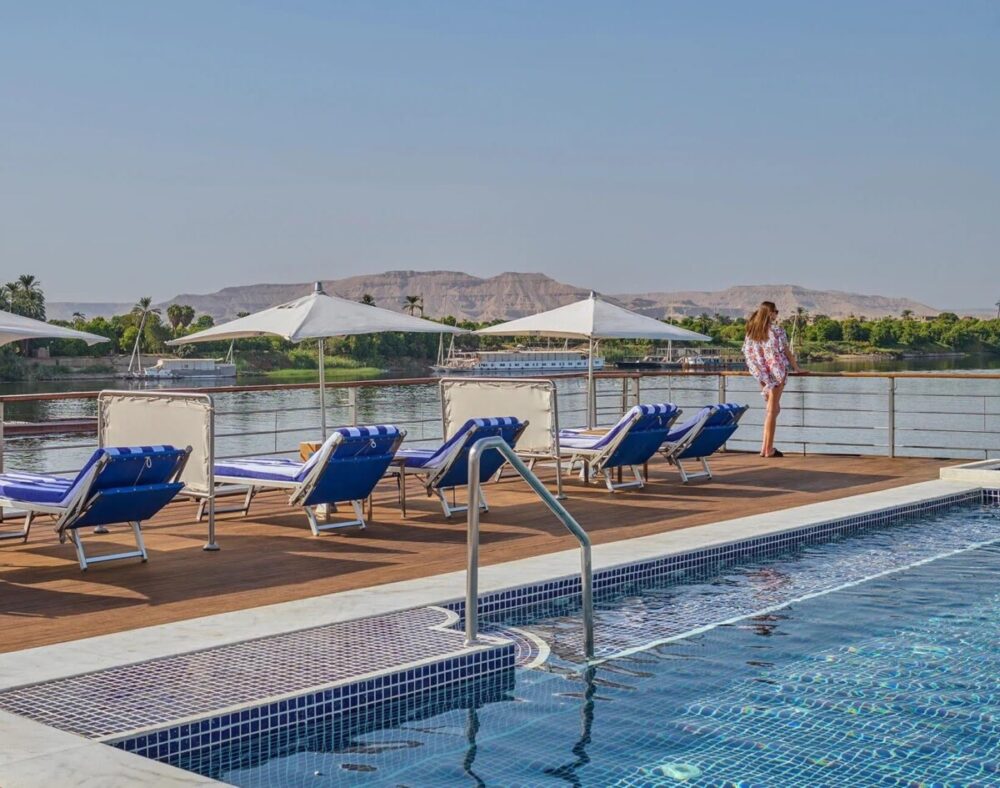 Best Time for a Nile Cruise: A Month-by-Month Guide 2 Woman standing on the upper deck, next to a swimming pool on a Nile cruise ship.