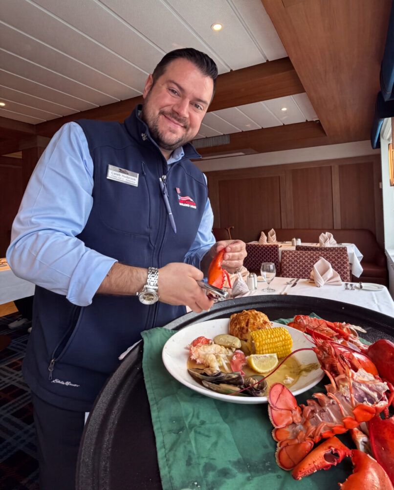 Explore Maine's Coast and Harbors Aboard American Cruise Lines 12 Hotel Manager Caleb cracking my lobster in the dining room