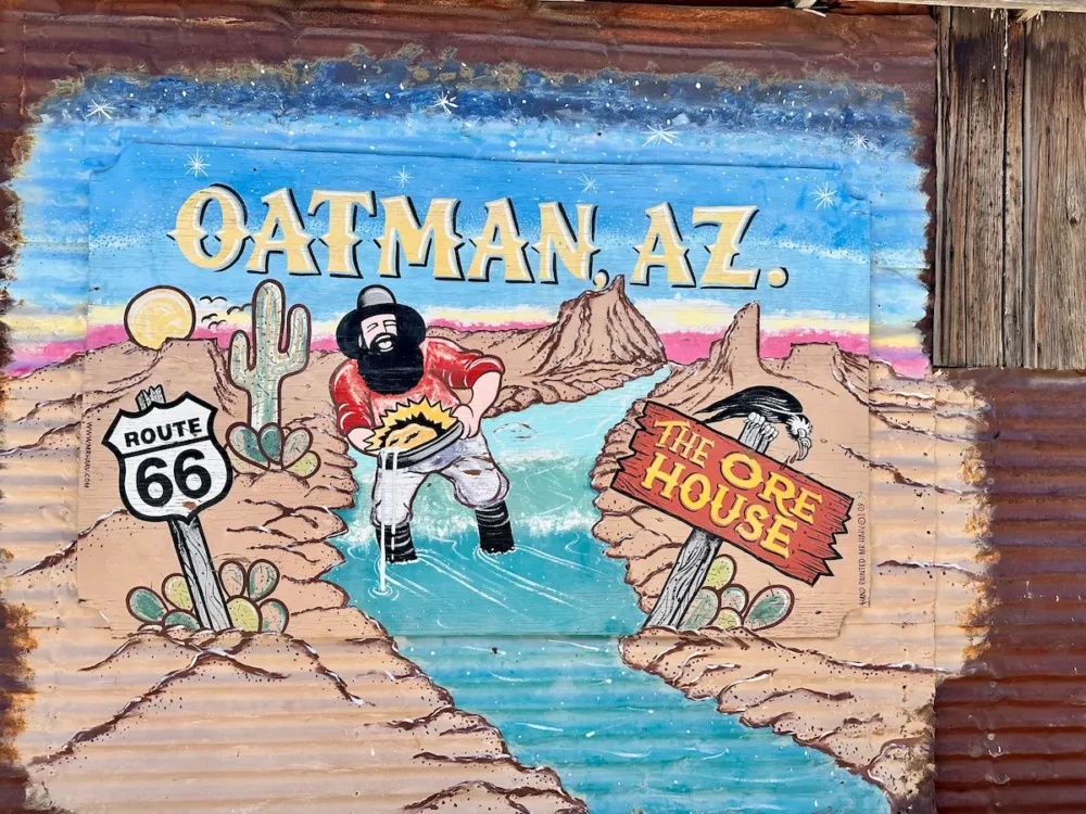 Wall in Oatman AZ showing a prospector and Route 66 sign