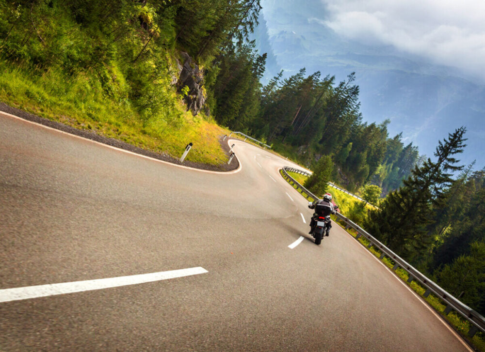 Biker in Austrian mountains riding on curve road