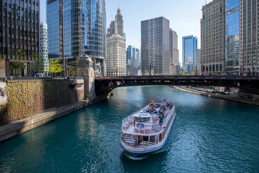 A view of the Chicago River from the State Street Bridge with a tour boat in the foreground and sky scrapers in the background